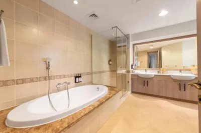 a bathroom with two sinks and a tub and a mirror at Ultra Luxury Palm - Free 5-star Beach Resorts Access in Dubai