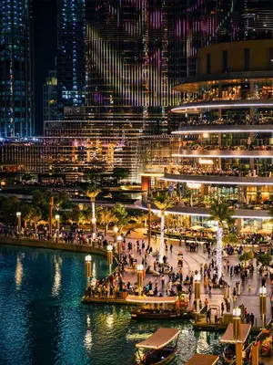 a view of a city at night with people walking at Cosmos Living 1 Bedroom Paramount Hotels in Dubai