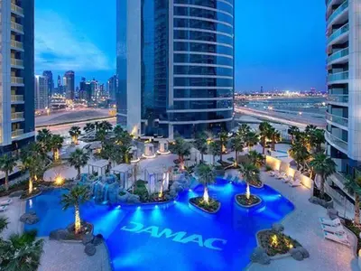 an aerial view of a resort at night at Cosmos Living 1 Bedroom Paramount Hotels in Dubai