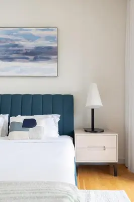 a bedroom with a bed with a blue headboard and a lamp at Welcome Home - Bluewaters brand new 2-bedroom in Dubai