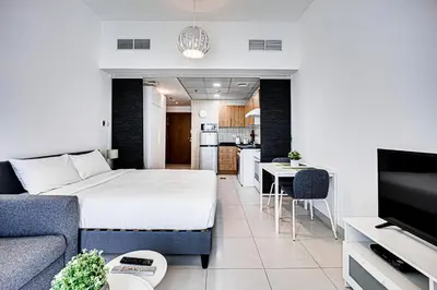 a living room with a bed and a kitchen at Canal View apartment in Marina in Dubai