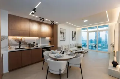 a kitchen and living room with a table and chairs at Sunrise Bay 2, Emaar Beachfront - Mint Stay in Dubai