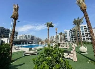 a resort with a pool and palm trees and benches at a chilled place in Dubai