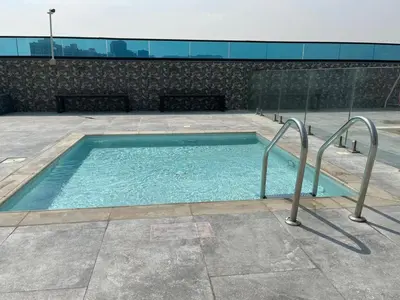 a swimming pool with two metal rails in a building at O2R26- Elegant Studio in O2 Residential Tower in Dubai