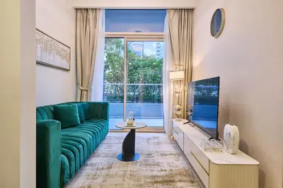 a living room with a green couch and a large window at Elegant 1BR in Vera Minutes from Dubai Mall in Dubai