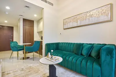 a living room with a green couch and a table at Elegant 1BR in Vera Minutes from Dubai Mall in Dubai