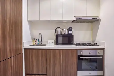 a kitchen with a microwave oven and a stove at Elegant 1BR in Vera Minutes from Dubai Mall in Dubai