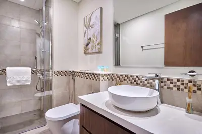 a bathroom with a sink and a toilet and a shower at Elegant 1BR in Vera Minutes from Dubai Mall in Dubai