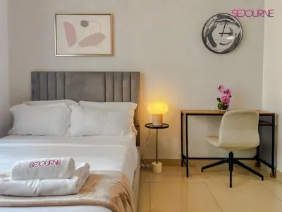 a bedroom with a bed with a chair and a table at LS10-Well Designed Studio In Lake Side Tower A in Dubai