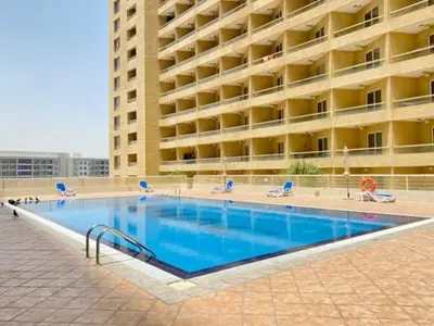 a large swimming pool in front of a large building at LS10-Well Designed Studio In Lake Side Tower A in Dubai