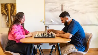a man and a woman playing chess at a table at Prestige holiday home Bed space in Dubai