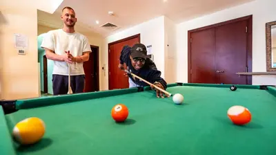 two men standing next to a pool table at Prestige holiday home Bed space in Dubai