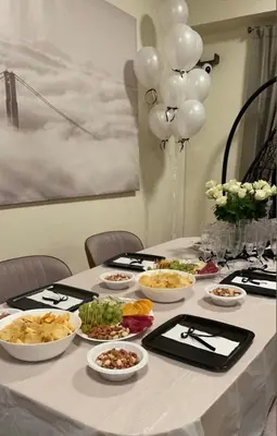 a table with plates of food and balloons on it at Prestige holiday home Bed space in Dubai