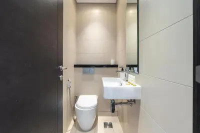 a bathroom with a toilet and a sink and a mirror at Vacay Lettings - Silverene Marina Retreat - Waterfront Apartment Steps from Marina Mall in Dubai