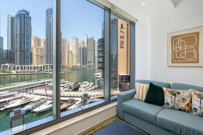 a living room with a couch and a large window at Vacay Lettings - Silverene Marina Retreat - Waterfront Apartment Steps from Marina Mall in Dubai