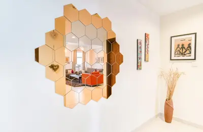 a mirror hanging on a wall in a living room at Luxury 1BR Apartment Executive Towers Business Bay in Dubai