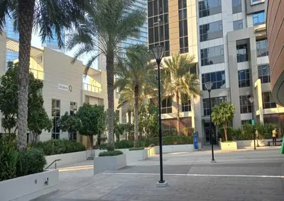 a courtyard with palm trees in a building at Luxury 1BR Apartment Executive Towers Business Bay in Dubai