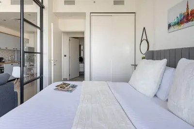 a bedroom with a large white bed with a mirror at Frank Porter - Collective Tower 1 in Dubai