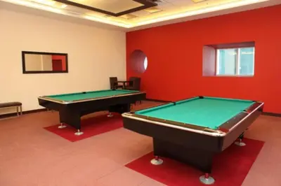two pool tables in a room with red walls at Dubai Marina Gem - Elite Residences 1BHK Retreat 4501 in Dubai