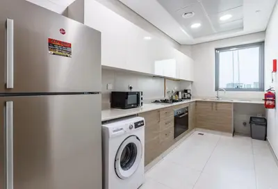 a kitchen with a refrigerator and a dishwasher at Elegant 2BR view with rooftop pool The Bay in Dubai