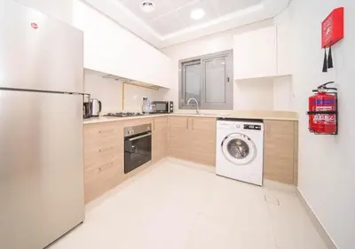 a kitchen with a refrigerator and a washing machine at Elegant 2BR view with rooftop pool The Bay in Dubai