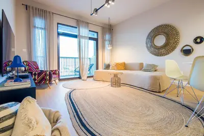 a bedroom with a bed and a living room at Burj Al Arab View - 1BR in MJL Lamtara 1- Burj Al Arab View 703 in Dubai