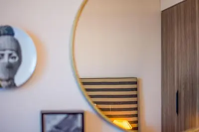 a mirror on a wall next to a wooden cabinet at Burj Al Arab View - 1BR in MJL Lamtara 1- Burj Al Arab View 703 in Dubai