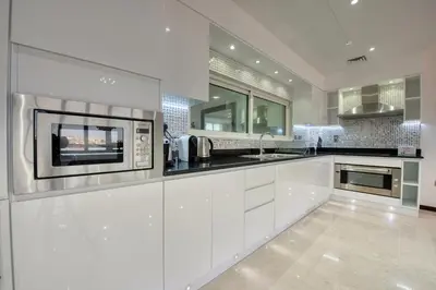 a kitchen with white cabinets and a microwave at Tiara Residence Ruby, Palm Jumeirah - Mint Stay in Dubai