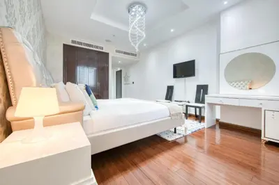 a white bedroom with a bed and a desk at Tiara Residence Ruby, Palm Jumeirah - Mint Stay in Dubai