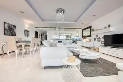 a living room with white furniture and a tv at Tiara Residence Ruby, Palm Jumeirah - Mint Stay in Dubai