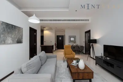 a living room with a couch and a tv at Tiara Beach Residences, Palm Jumeirah Dubai - Mint Stay in Dubai