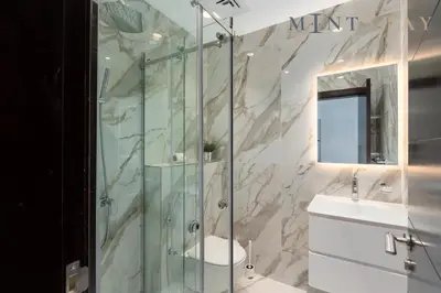 a bathroom with a glass shower and a sink at Tiara Beach Residences, Palm Jumeirah Dubai - Mint Stay in Dubai
