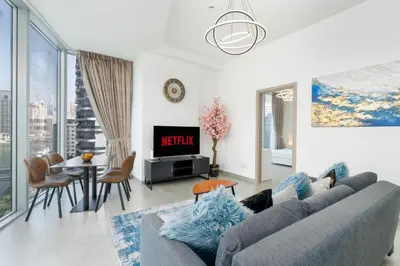 a living room with a couch and a table at Vacay Lettings - Waterfront Luxury home with full Marina view in Dubai