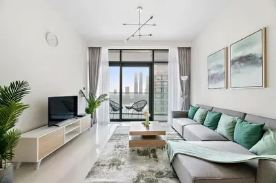 a living room with a couch and a tv at Free Beach Access! Beautiful Palm Jumeirah & Dubai Eye in Dubai
