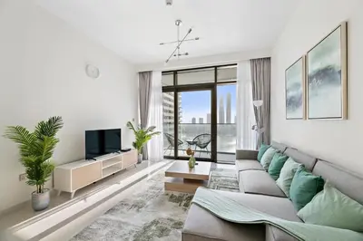 a living room with a couch and a tv at Free Beach Access! Beautiful Palm Jumeirah & Dubai Eye in Dubai