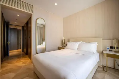 a bedroom with a large white bed and a mirror at FIVE Palm Jumeirah 2BR Luxury Penthouse, Private Pool, Full Marina Sea View in Dubai