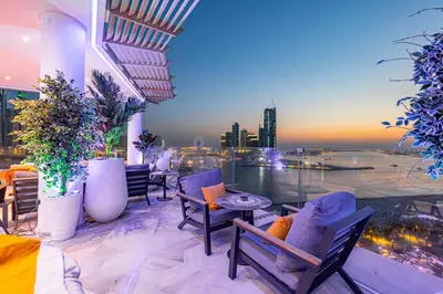a balcony with chairs and tables and a view of a city at FIVE Palm Jumeirah 2BR Luxury Penthouse, Private Pool, Full Marina Sea View in Dubai
