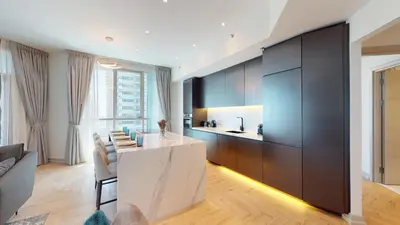 a kitchen with black cabinets and a white counter at Vacationer I Glamorous 2 Bedroom I Steps from Barasti Beach I Marina Views in Dubai