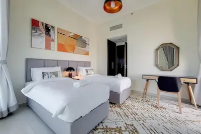 a bedroom with two beds and a desk and a mirror at Bay Central, Central Tower - Tranquil Two Bedroom in Dubai