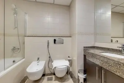 a bathroom with a toilet and a sink and a shower at Bay Central, Central Tower - Tranquil Two Bedroom in Dubai