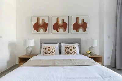 a bedroom with a bed with three pictures on the wall at Frank Porter - Pulse C2 in Dubai