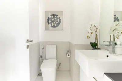 a white bathroom with a toilet and a sink at Frank Porter - Pulse C2 in Dubai