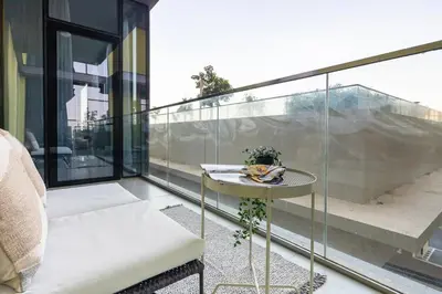 a glass balcony with a table and a plant on it at Frank Porter - Pulse C2 in Dubai