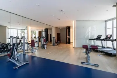 a gym with treadmills and cardio equipment in a room at DAMAC MAISON PRIVE - Deluxe Studio With Balcony & Water Canal View in Dubai