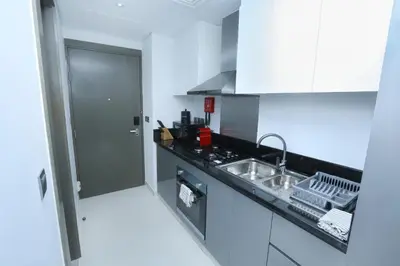 a kitchen with a sink and a counter top at DAMAC MAISON PRIVE - Deluxe Studio With Balcony & Water Canal View in Dubai