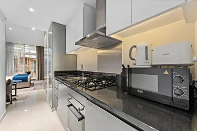 a kitchen with a stove and a microwave at ALiving Luxury Studio I DAMAC Maison Prive A- 1007 in Dubai