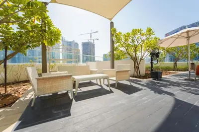 a patio with chairs and tables and an umbrella at ALiving Luxury Studio I DAMAC Maison Prive A- 1007 in Dubai