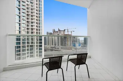 a balcony with two chairs and a view of a city at ALiving Luxury Studio I DAMAC Maison Prive A- 1007 in Dubai