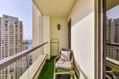 a balcony with a chair and green grass at Luxury JBR · Marina View · 5* Beach Resorts Access in Dubai