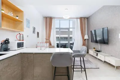 a kitchen with a table and chairs in a room at Perfect 2br for families in JVC in Dubai